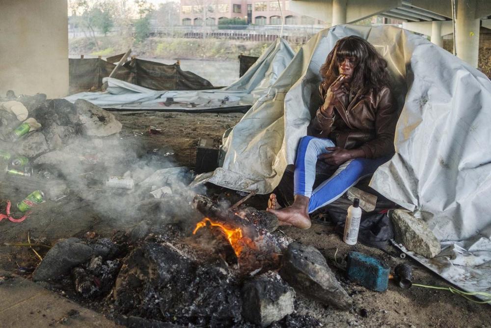  A homeless person warms their feet with a small fire on a cold morning in Macon in late 2023.