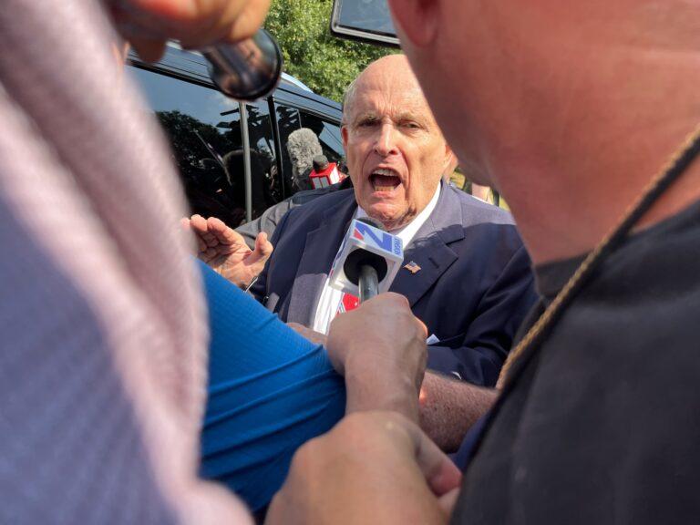 Rudy Giuliani is surrounded by media outside the Fulton County jail as he surrendered Aug. 23, 2023 on criminal charges. 