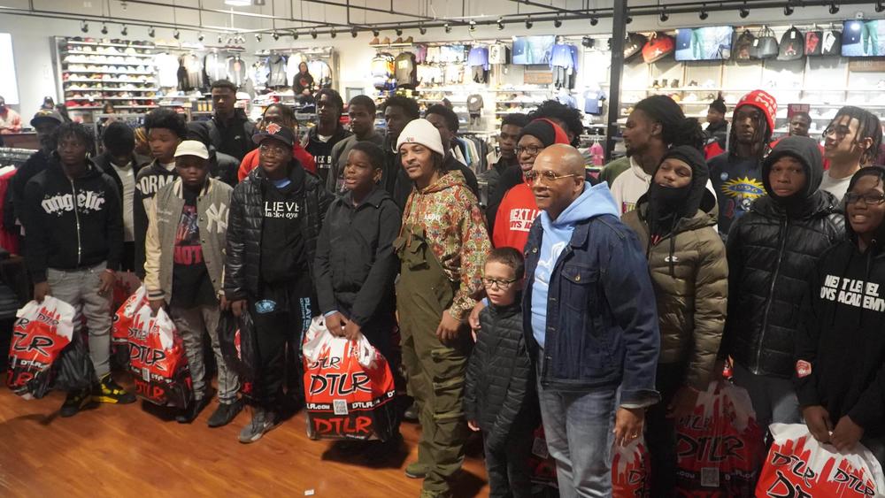 Tip 'T.I.' Harris poses with participants in the Next Level Boys Academy during a shoe giveaway in Atlanta in December 2023.