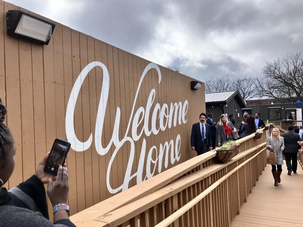 A “Welcome Home” mural greets tenants and visitors to Atlanta’s first rapid housing community for those experiencing homelessness. The project was built on a former city parking lot and includes 40 micro-units made from repurposed shipping containers. (Dyana Bagby)