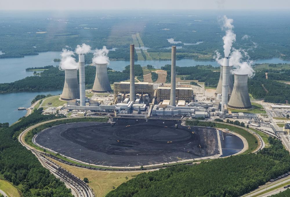 Massive trucks and front end loaders look ant-sized relative to the coal piled in front of Georgia Power's Plant Scherer in this photo from 2019. 