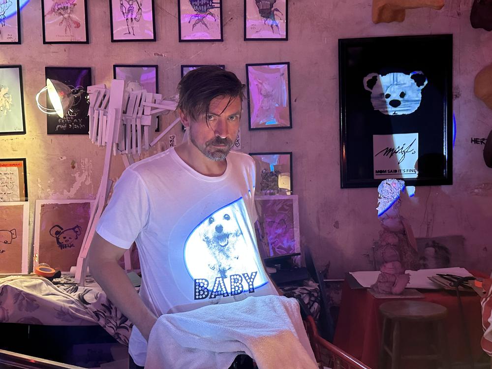 Atlanta artist Mike Stasny stands in front of his art inside Mom Said Its Fine, his studio and performance space in Underground Atlanta. 