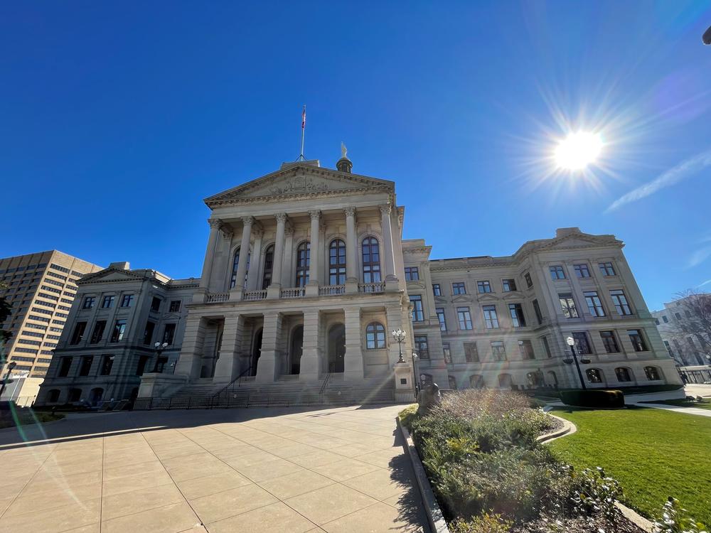 front lawn view of Georgia state capitol building with sun shining