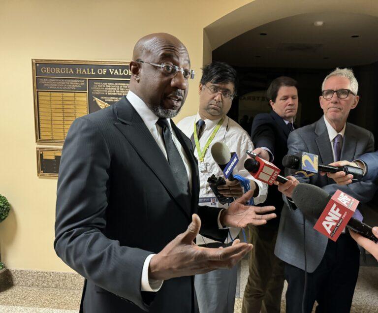 U.S. Sen. Raphael Warnock talks to reporters at the state Capitol Tuesday.