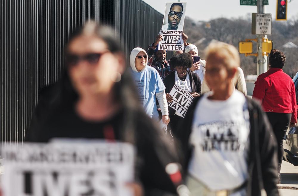 Isaac Lester carries a photo of his son, Isaac Lester, Jr., as he and other prison rights advocates march to the entrance of the Georgia State Capitol. Lester says his son died from an acute asthma attack because the prison where he was incarcerated did not have adequate health care. 