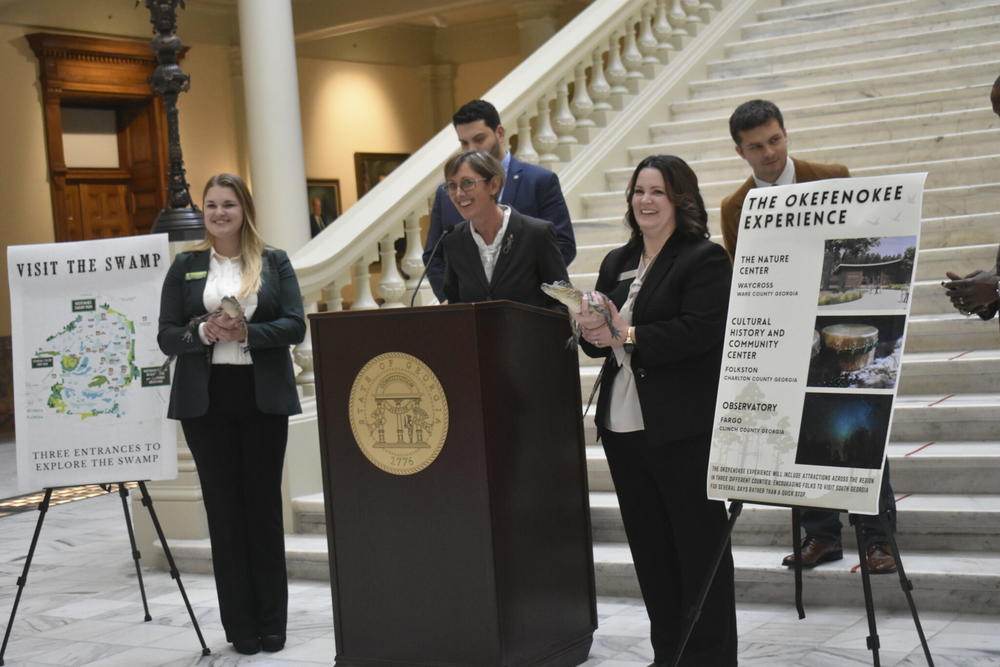  Kim Bednarek, executive director of Okefenokee Swamp Park, speaks at the Georgia Capitol while Jolie Hoyle and Katie Antczak handle two of the park’s resident gators, Creature and Charlie. Ross Williams/Georgia Recorder