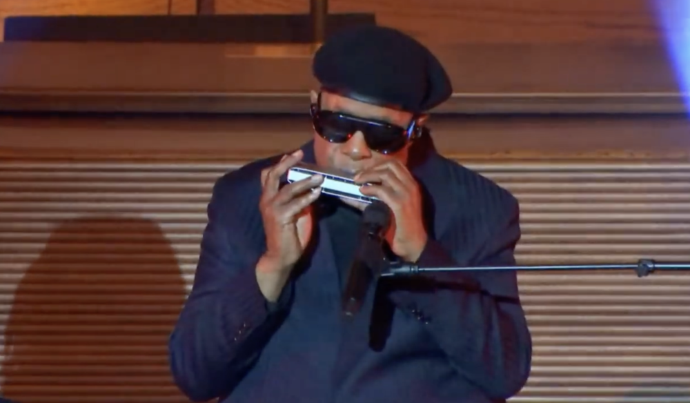 Stevie Wonder plays harmonica during "Total Praise," a gospel song he performed at the memorial service for Dexter Scott King on Feb. 10, 2024.