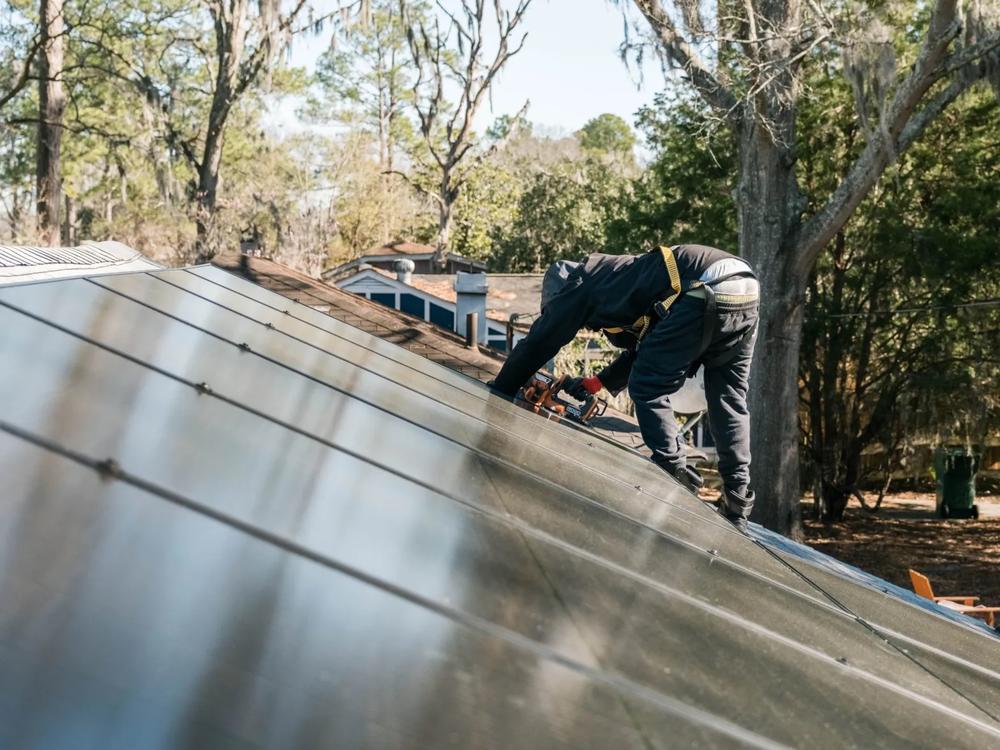 A worker installs solar panels on a roof, Feb. 6, 2024, Garden City. Credit: Justin Taylor/The Current