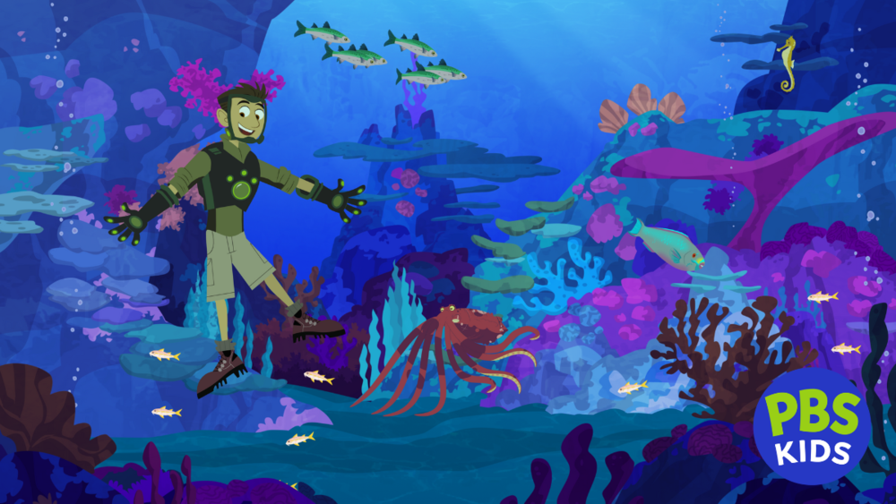 Chris Kratt is in the ocean, surrounded by coral reef and sea creatures