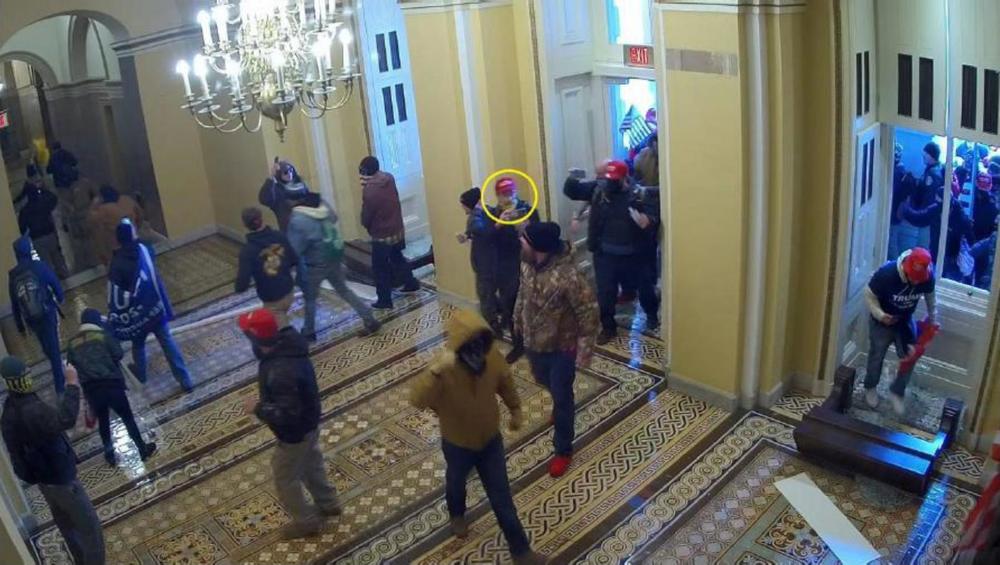 In this frame from U.S. Capitol surveillance video, the man in the yellow circle is identified by the FBI as Dominic Box, entering through the Senate wing door of the building on Jan. 6, 2021.