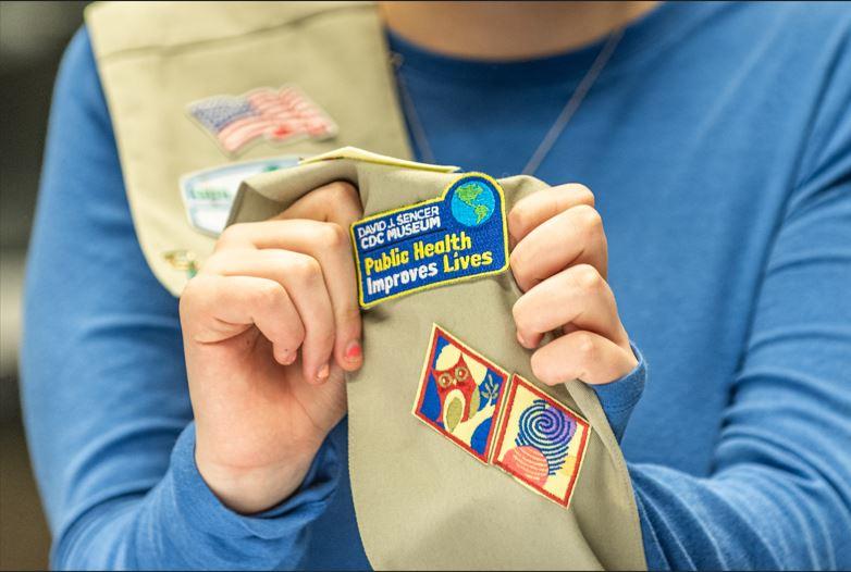 A public health patch sewn on a Girl Scout sash