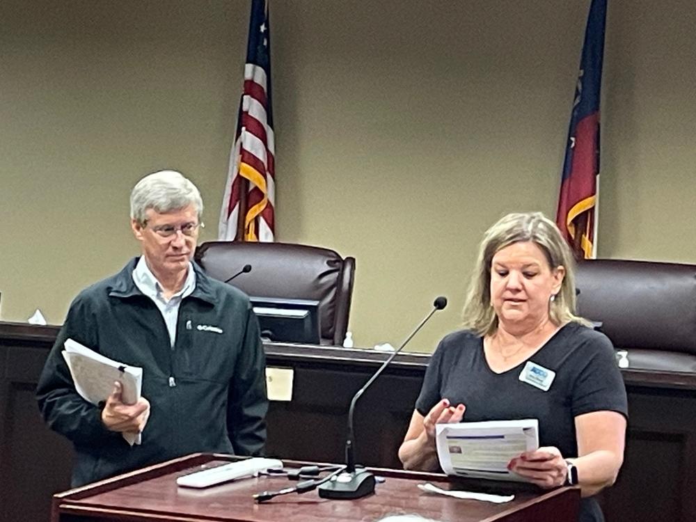 Dave Wills stands next to Beth Brown at the podium during a March 21 meeting.