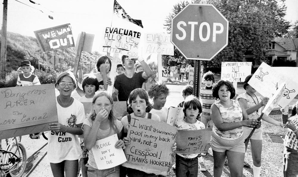 A black and white photo of children marching in protest with signs.