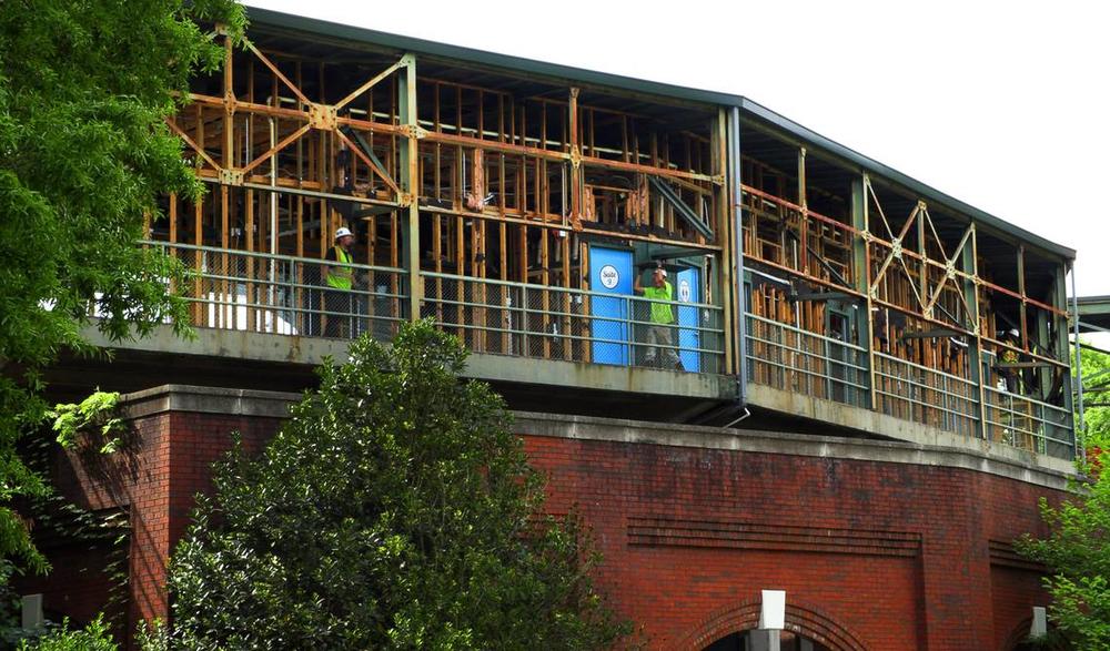 Workers carry debris to a dumpster while working on the suite level at Golden Park in Columbus, Georgia. 04/17/2024 Mike Haskey mhaskey@ledger-enquirer.com  