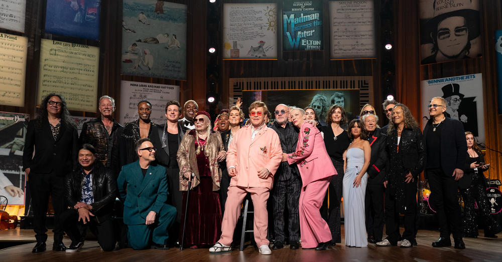 Elton John and Bernie Taupin on stage with other performers