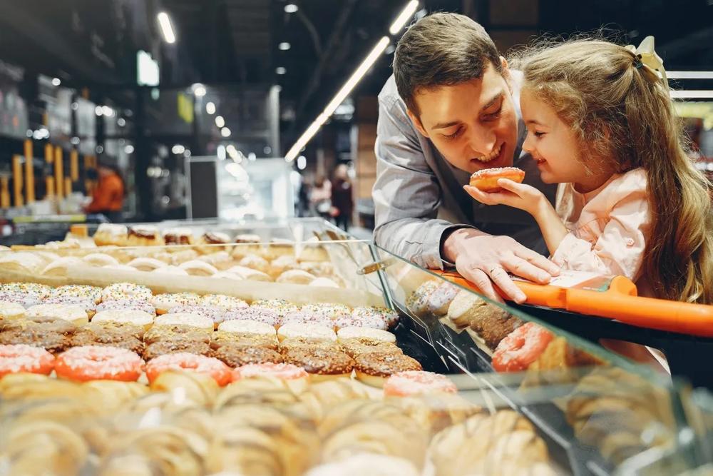 A man and a small girl holding a donut
