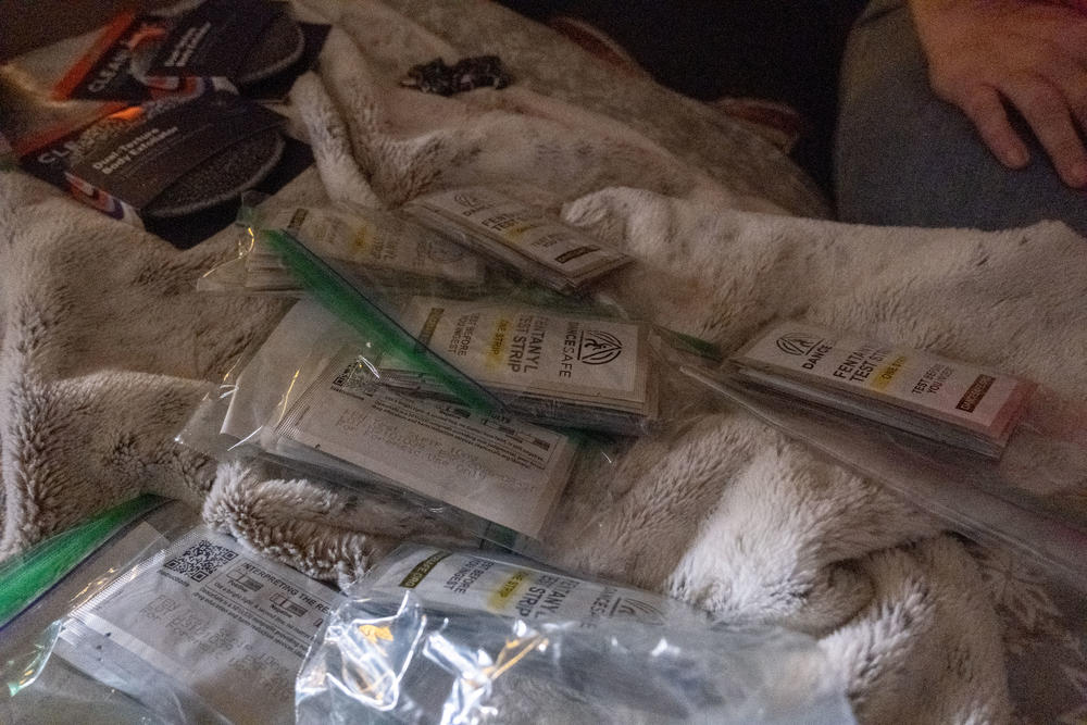 A pile of fentanyl test strips, used to detect the presence of fentanyl in injectible drugs, sits on a motel room bed in Augusta.