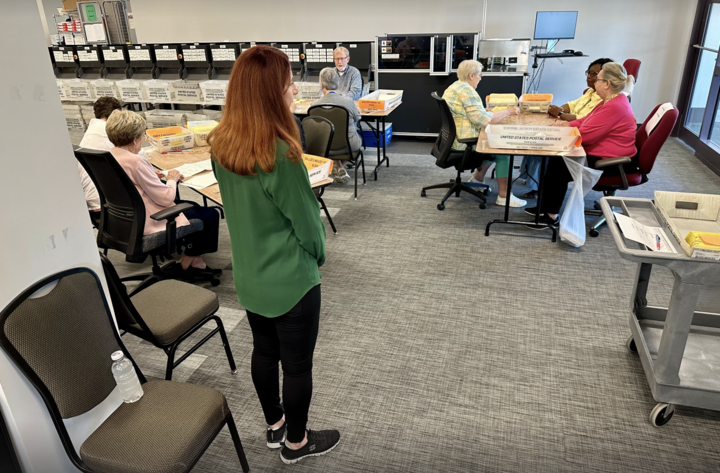A Republican monitor overlooks the opening of absentee ballot envelopes at the Cobb County elections office in Marietta, Ga., on the Monday before the May primary. Matt Vasilogambros/Stateline