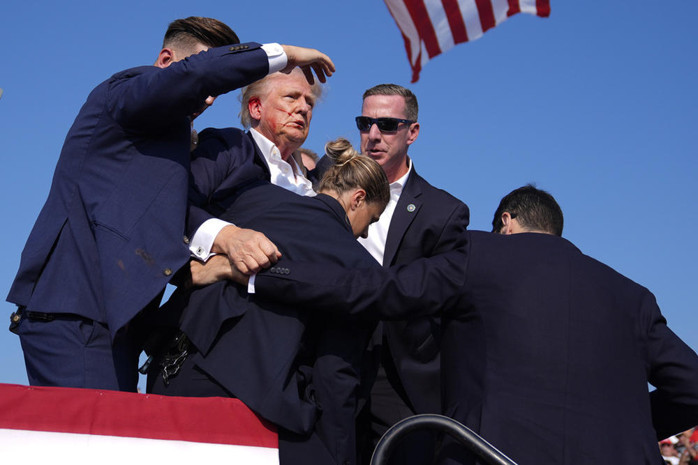 Republican presidential candidate former President Donald Trump is surrounded by U.S. Secret Service agents at a campaign rally, Saturday, July 13, 2024, in Butler, Pa. 