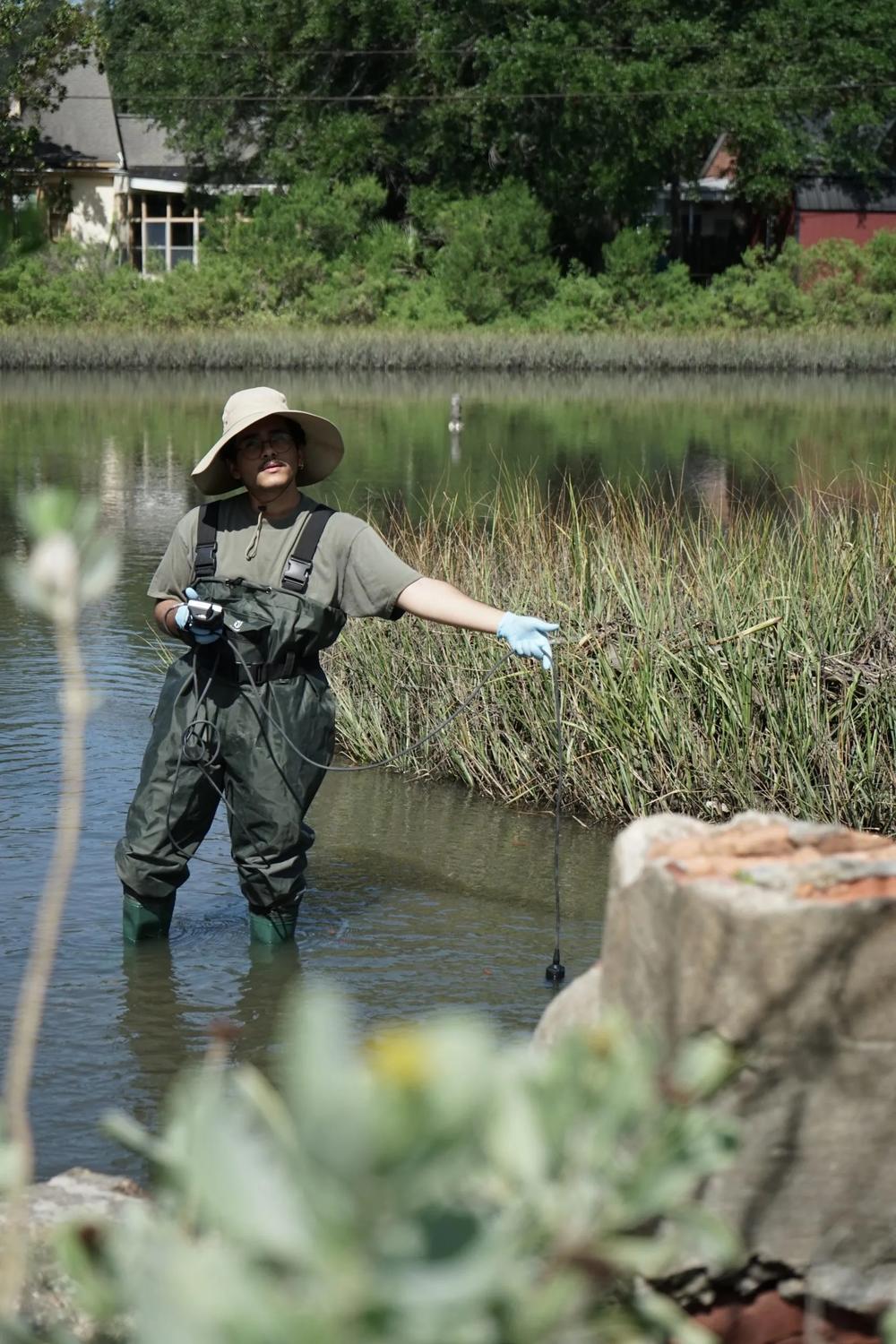 Josh Brown, an undergraduate researcher from Georgia Southern, steps into a retention area to measure oxygen levels in the water. Credit: Serra Sowers/The Current