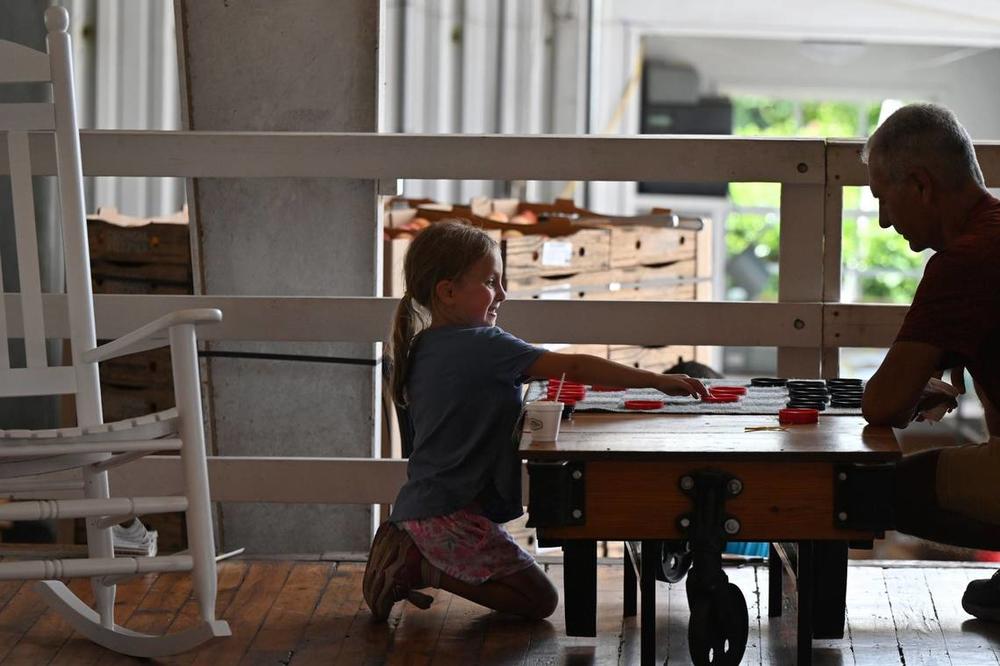 Annie Cordeira (left), 6, plays checkers at Dickey Farms on Wednesday, July 3, 2024, in Musella, Georgia. Dickey Farms is the oldest, continuously operating peach packinghouse in Georgia and offers tours and sells homemade goods and produce in their shop. Katie Tucker/The Telegraph