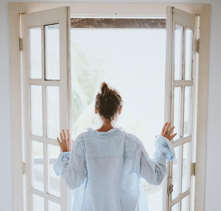 A woman opens a set of double doors 