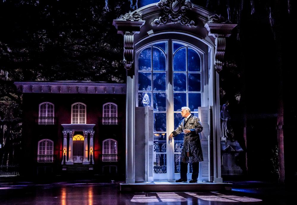 Tom Hewitt as Jim Williams, the wealthy socialite and historic preservationist accused of murder. At left is a replica of the Mercer-Williams House, where he lived and where the fatal shooting took place in “Midnight in the Garden of Good and Evil”