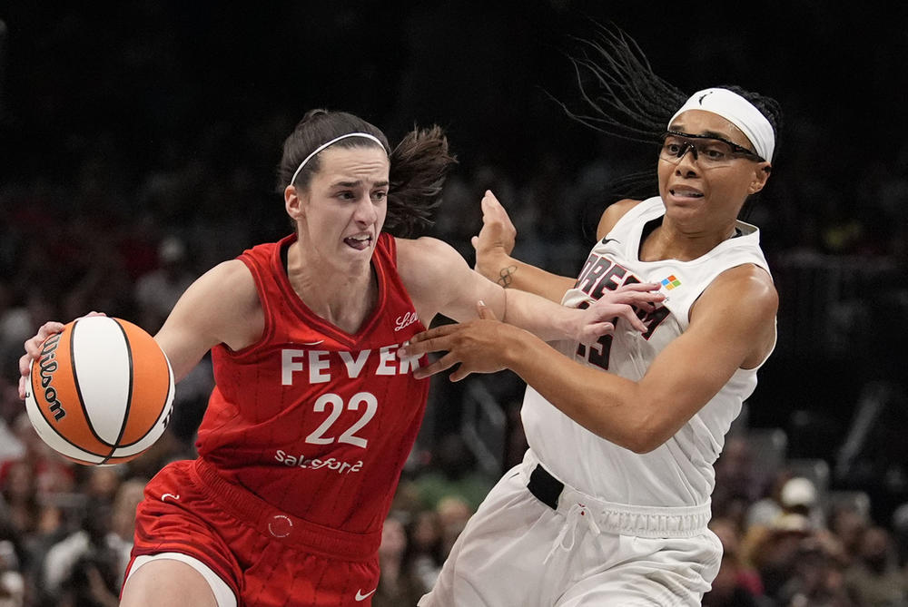 Indiana Fever's Caitlin Clark (22) dribbles the ball against Atlanta Dream's Allisha Gray (15) in the first half of an WNBA basketball game, Monday, Aug. 26, 2024, in Atlanta. (AP Photo/Brynn Anderson)