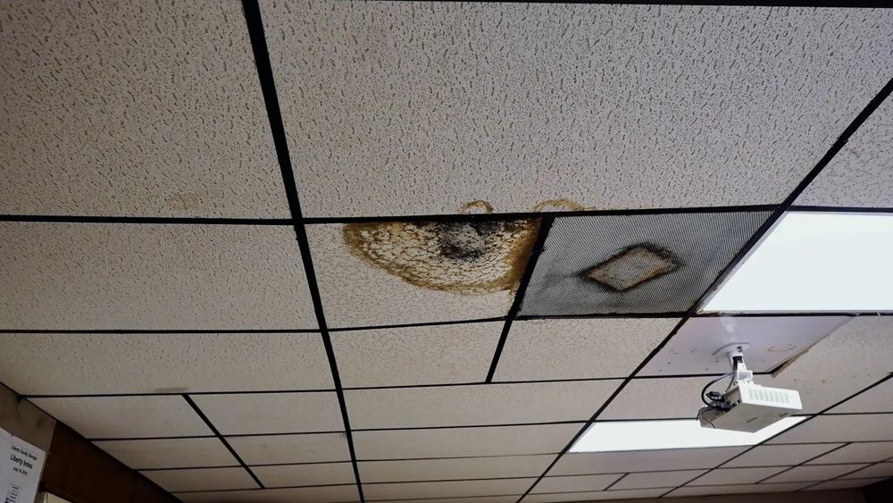 Black mold and water damage on the ceiling of the Midway Volunteer Fire Department. Deputy Chief Jonathan Campbell said he zip-tied the bowed ceiling a couple of years ago to keep it from falling. Councilmembers heard three bids to remove asbestos and install foam insulation but did not act at the July 15, 2024 meeting, about an hour before this photo was taken. Credit: Robin Kemp/The Current GA