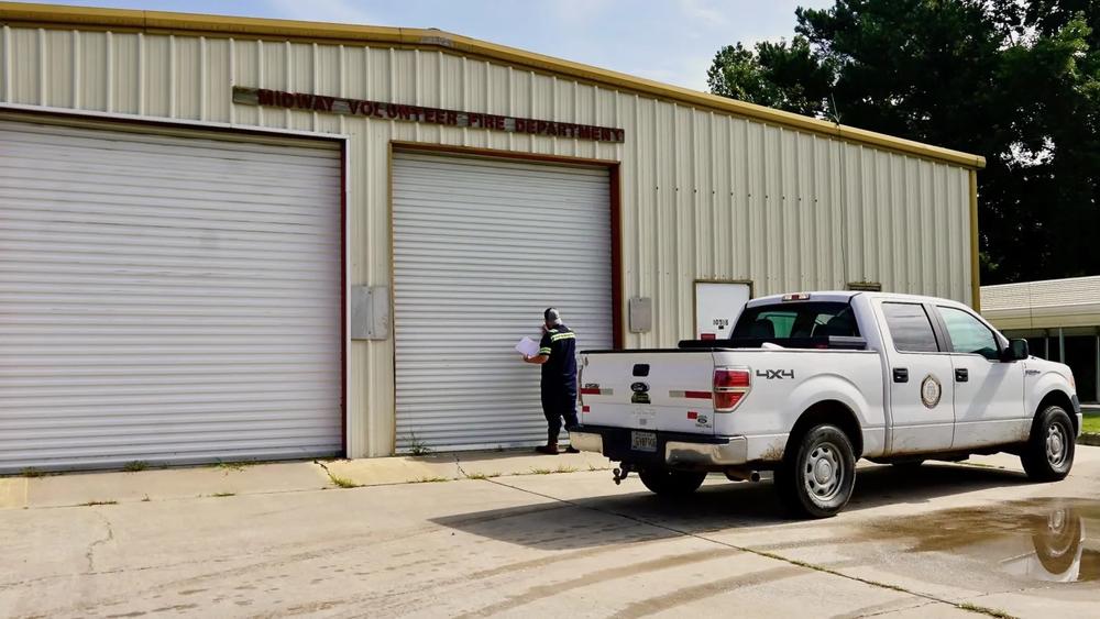 A Midway Public Works employee removes a sign from the Midway Volunteer Fire Department, July 25, 2024. The city did not say how the signs appeared. Credit: Robin Kemp/The Current GA