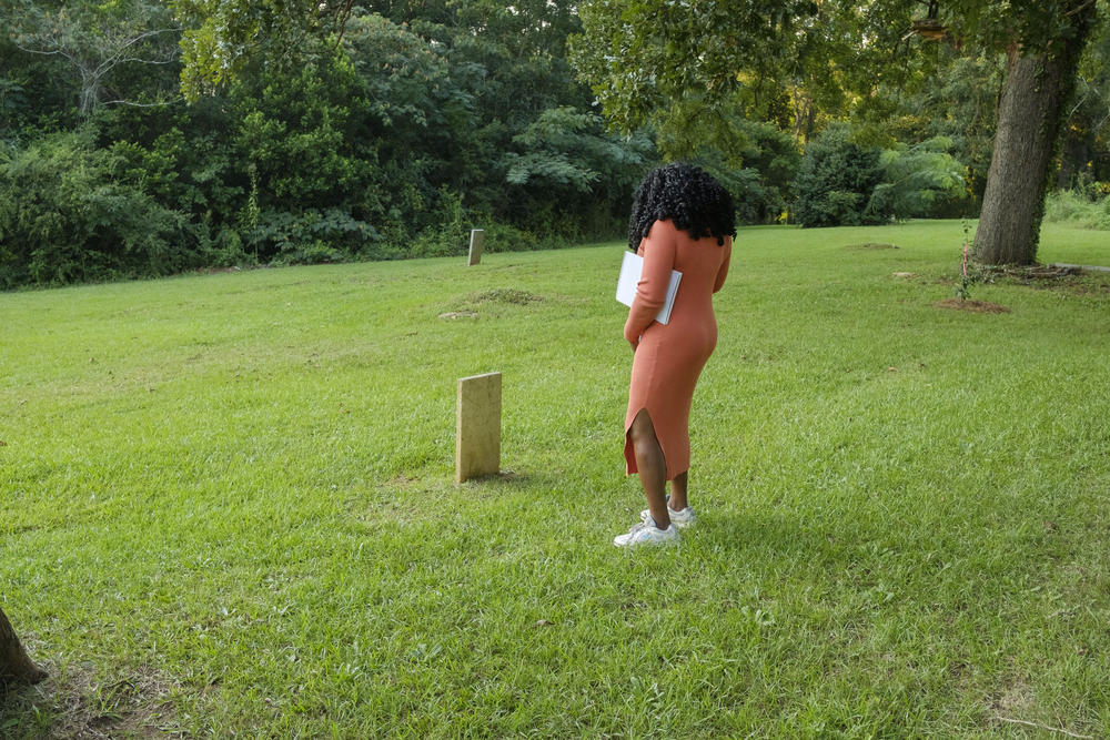 Stephanie Woods Miller pauses during a tour of Macon’s Oak Ridge Cemetery to look at one of the few grave markers on a hillside researchers now think may be the final resting place of thousands of African American residents of Macon dating back to the 1840s.