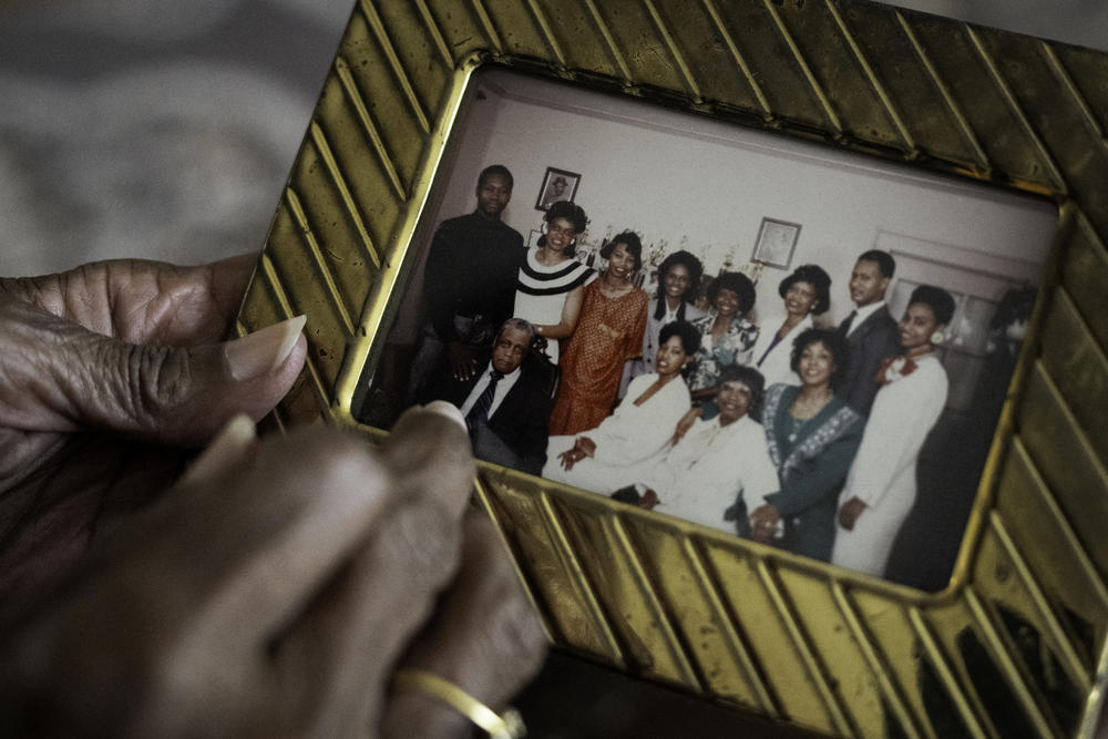 Cookie holds a photograph of her nine siblings and parents. Scholastic achievement was at the heart of their upbringing.