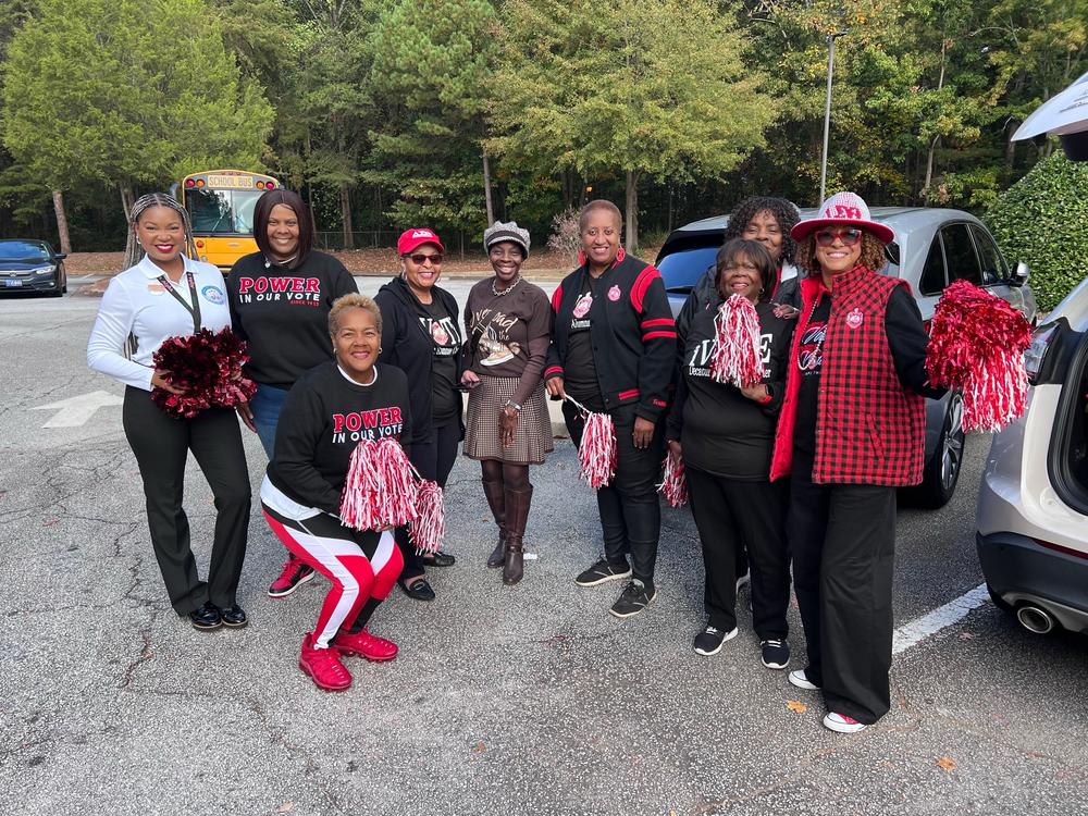 The picture of the women with the red and white pompoms is of NPHC of Dekalb members preparing to cheer newly registered high school students  before they vote.