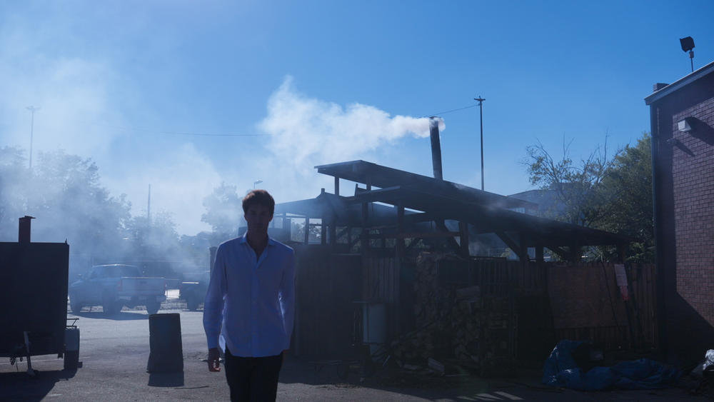 A man walking through smokers.
