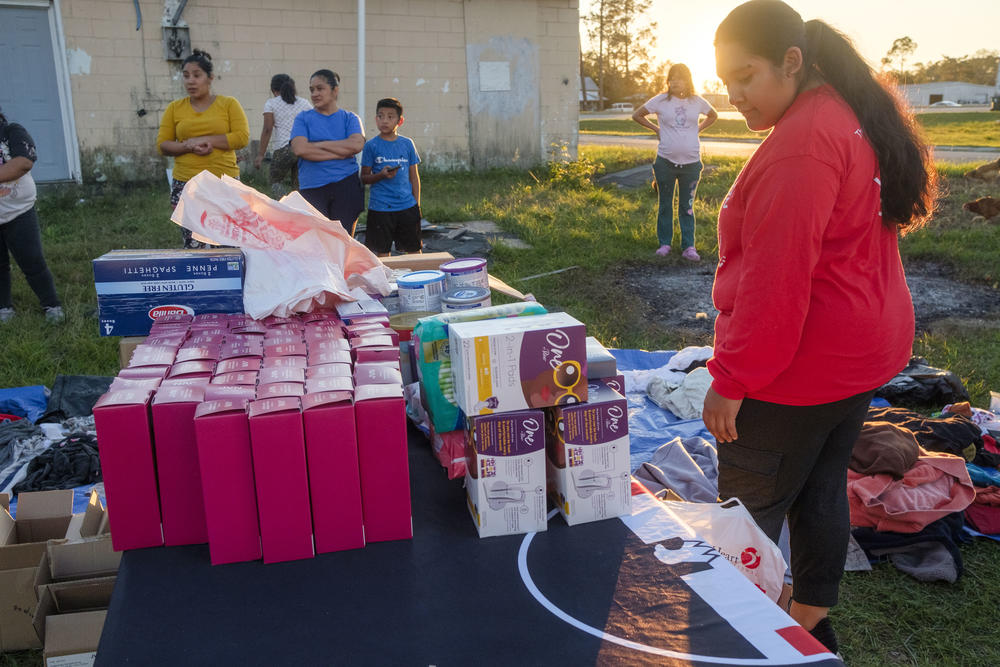 United Farm Workers organizer Anahi Santiago, right, dispenses items to a community of Latino laborers still recovering from Hurricane Helene east of Tifton. 