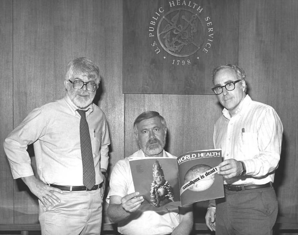 This 1980 photograph, taken at the Centers for Disease Control, depicted three former directors of the Global Smallpox Eradication Program, as they read the good news that smallpox had been eradicated on a global scale. From left to right: Dr. J. Donald Millar, who was director 1966–70, Dr. Bill Foege, who was director 1970-73, and Dr. J. Michael Lane, who was director 1973-81.  (CDC) 