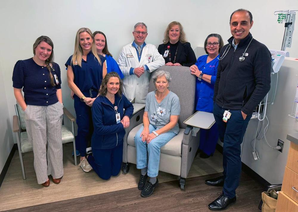 Susan Williams,seated center, a patient at the John B. Amos Cancer Center in Columbus, Georgia, is receiving a new cancer treatment known as Bispecific T-Cell Engager (BiTE) therapies on Feb. 11, 2025. Here, she is photographed with some of her care providers. Credit: Mike Haskey/Columbus Ledger-Enquirer