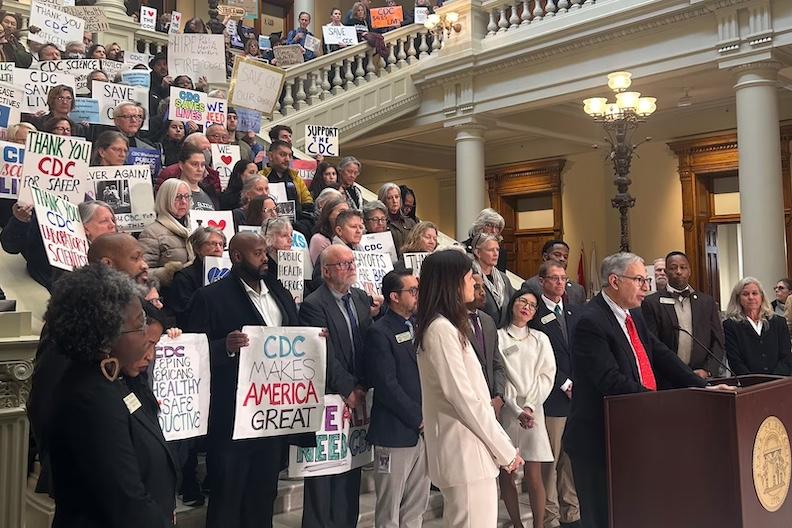 Workers who were laid off from the Centers for Disease Control and Prevention in Atlanta, and their supporters, speak at the Georgia Capitol on Friday. (Rebecca Grapevine / Healthbeat) 