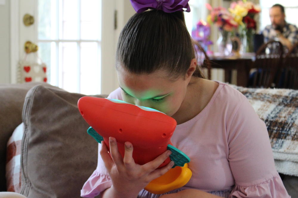 Lydia Dobbs presses her face to her toy