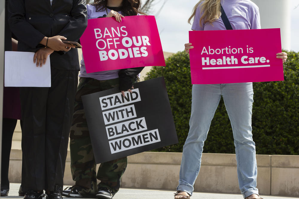 Signs at a reproductive justice rally on March 13, 2025.