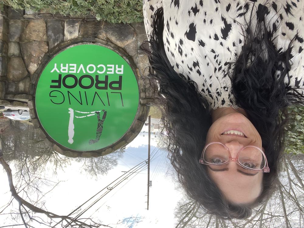 Brittney Galvanauskas stands in front of a Living Proof Recovery sign