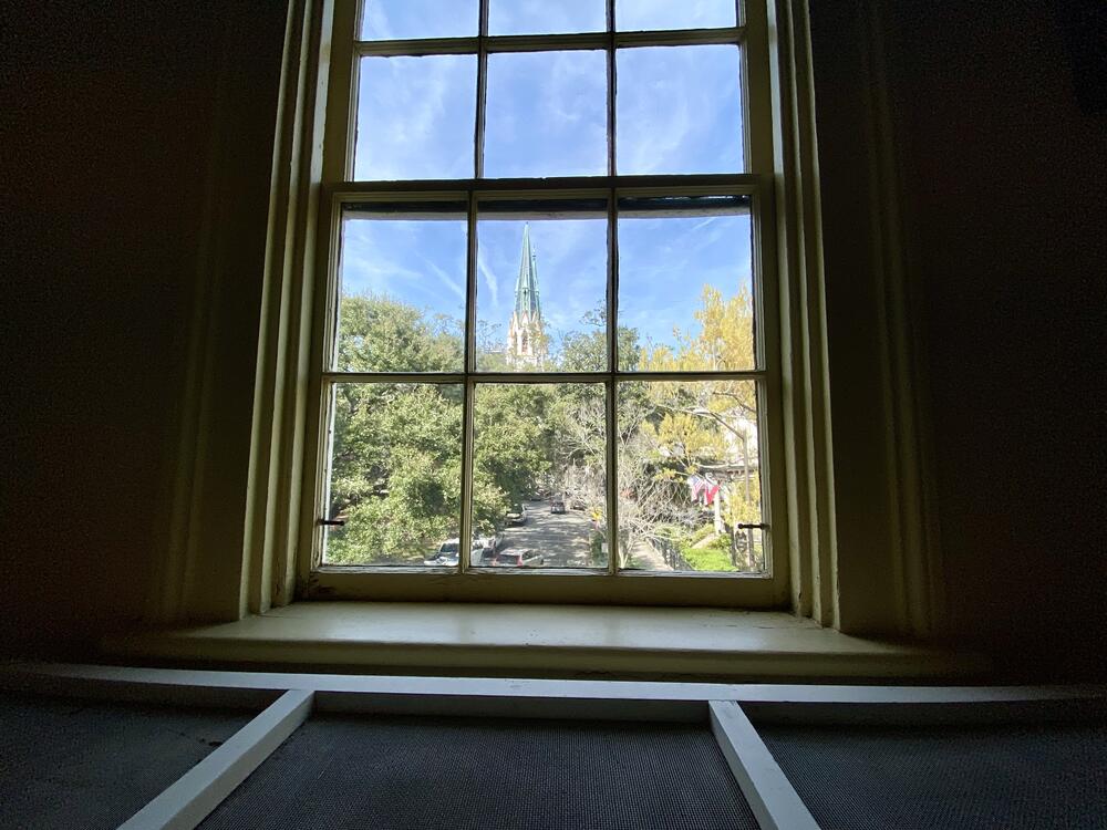 Flannery O'Connor's baby crib, located in her parents' upstairs bedroom, overlooks the Cathedral Basilica of St. John the Baptist, where the family attended Catholic mass.