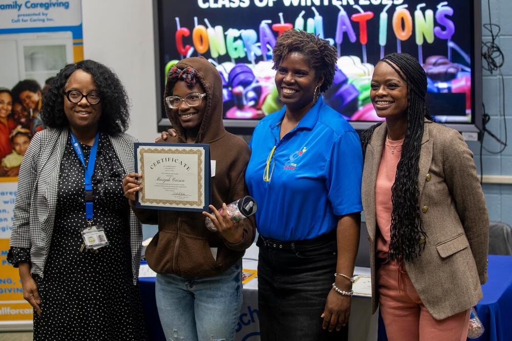 Charles Drew High School freshman Mariyah Carson, (second from left) poses for a photo with Charles Drew High School principal Tangela Benjamin (left), Call for Caring Inc. founder Michelle Bolden (second from right) and Dementia educator Carrie Harris (right) during the Young, Gifted and Caregiving inaugural class at Charles Drew High School in Riverdale, Georgia, March 12. (Alyssa Pointer for Healthbeat) 