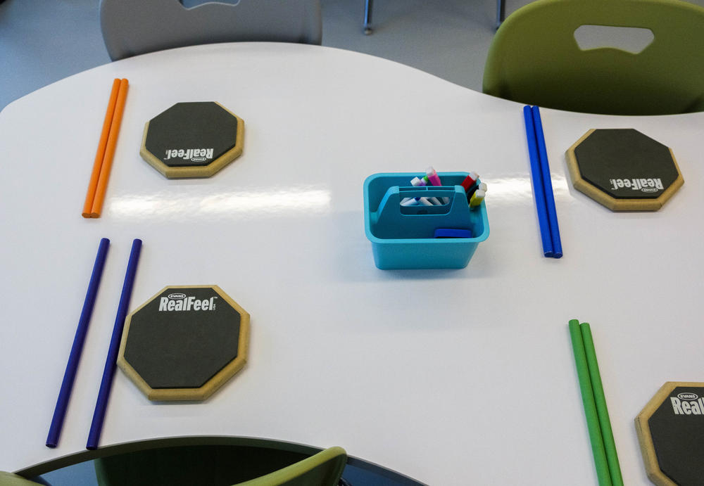Drummers' practice pads, drum sticks, markers and a deks meant likely meant to be sketched on in a classroom of the Otis Redding Center for the Arts. 