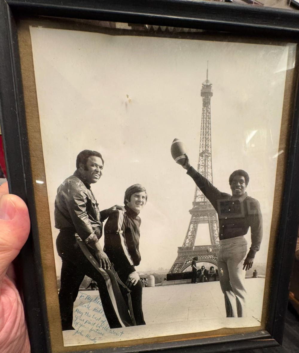 Young Bill Curry poses in front of Eiffel Tower with friends