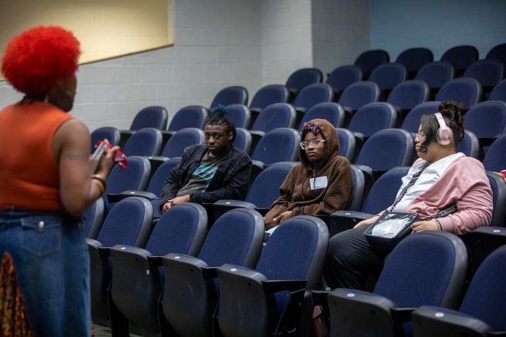 Charles Drew High School students Zahion Mikell (from left), Mariyah Carson and Aaliyah Taylor listen to Dr. Adrienne during the Young, Gifted and Caregiving inaugural class at Charles Drew High School in Riverdale, Georgia, March 12. (Alyssa Pointer for Healthbeat) 