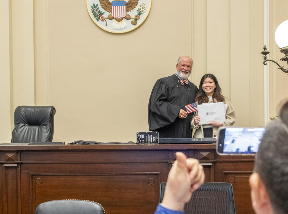 Cindy Ngo, a civil engineering student at the University of Georgia, poses with Federal Judge Tillman Self III after Self presided over the naturalization ceremony for Ngo and 21 others in Macon. 