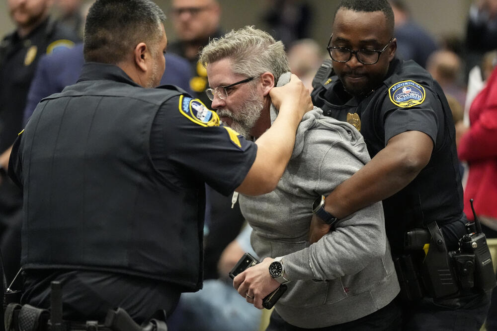 A protester is removed as Rep. Marjorie Taylor Greene, R-Ga., speaks during a town-hall style meeting, Tuesday, April 15, 2025, in Acworth, Ga.