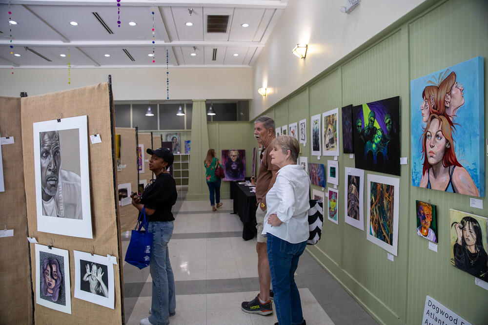 Attendees look at visual art made by high school students
