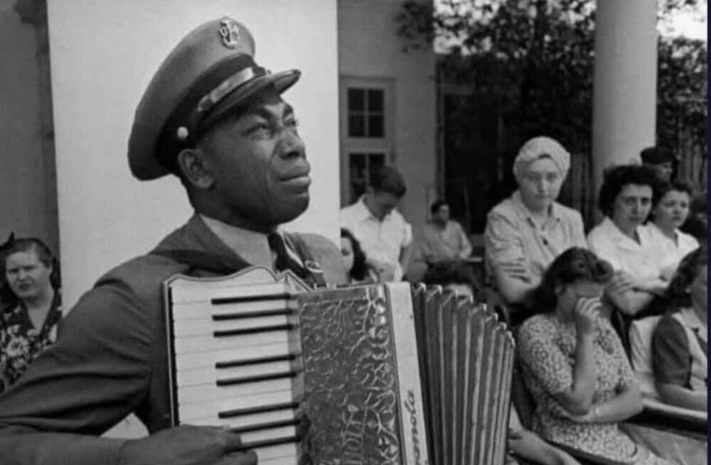 Chief Petty Officer Graham W. Jackson, U.S. Navy, playing “Dvořák’s Goin’ Home” on his accordion as President Franklin D. Roosevelt’s flag-draped casket passed by in Warm Springs, April 1945.